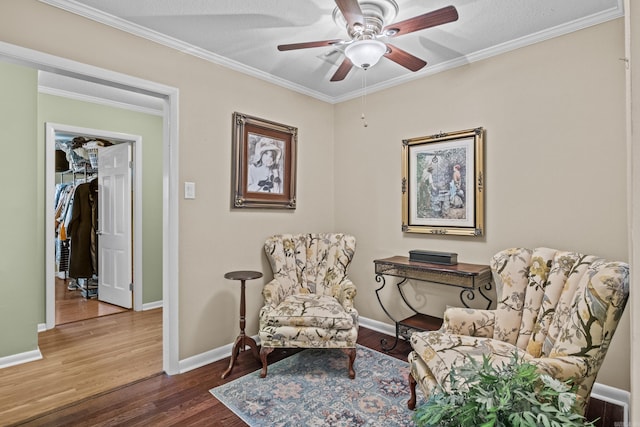 living area featuring ceiling fan, ornamental molding, wood finished floors, and baseboards