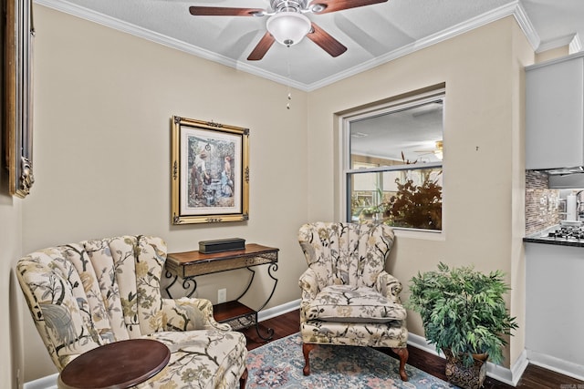 living area featuring a ceiling fan, baseboards, ornamental molding, and wood finished floors