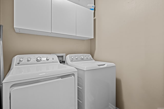 clothes washing area with cabinet space and washer and clothes dryer