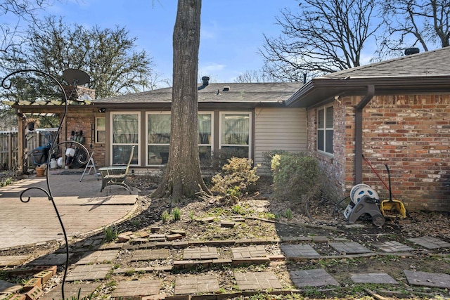 back of property with brick siding, a patio, and fence