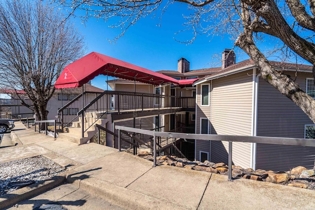 rear view of property featuring stairs and a chimney