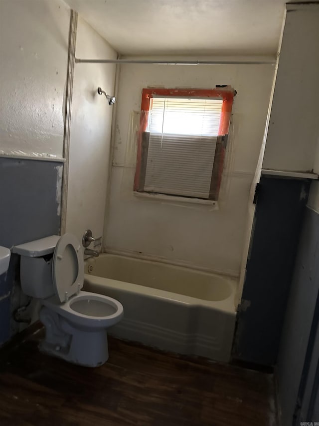 full bath featuring toilet, wood finished floors, and bathing tub / shower combination