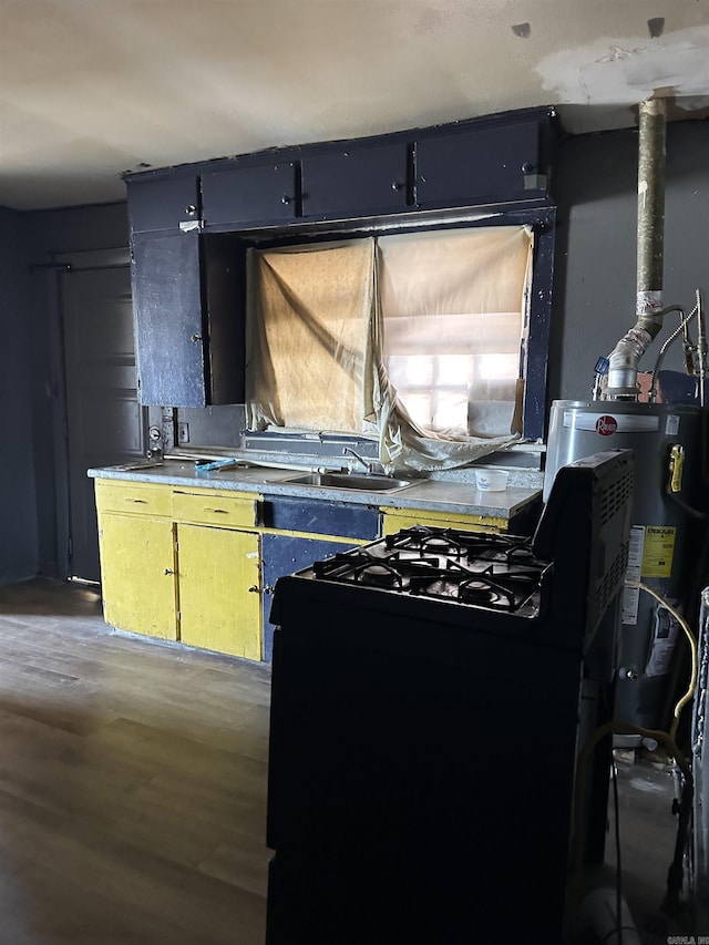 kitchen featuring water heater, wood finished floors, gas stove, and a sink