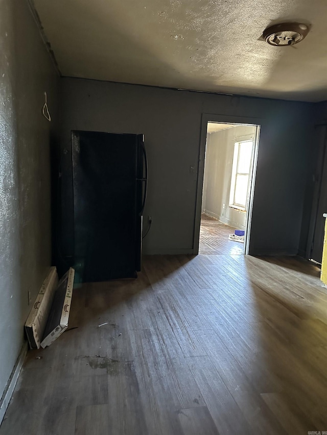 empty room featuring a textured ceiling and wood finished floors