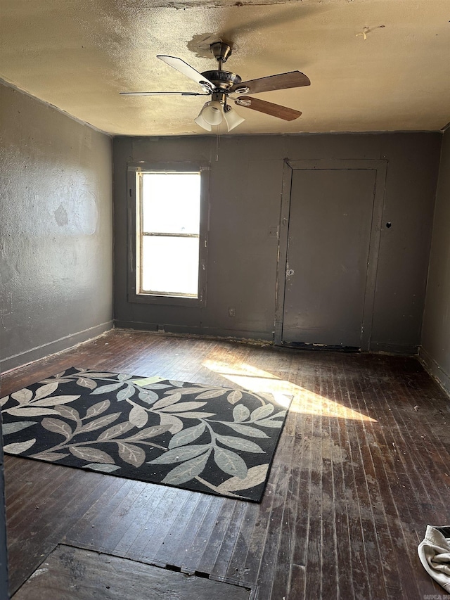 spare room with wood-type flooring and baseboards