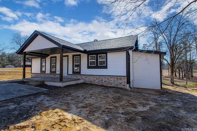 view of front of house with a shingled roof and a porch