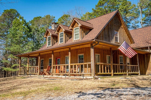 view of front of home featuring covered porch, a shingled roof, board and batten siding, and a chimney