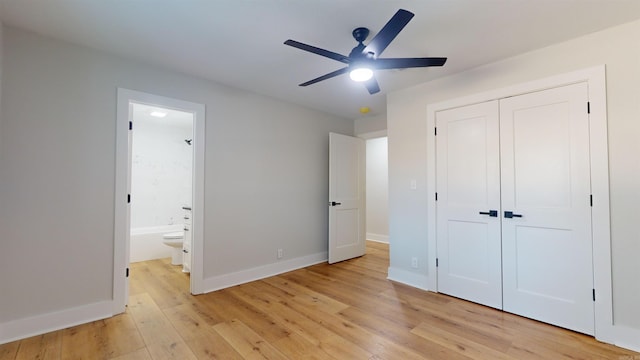 unfurnished bedroom featuring light wood-type flooring, a closet, ensuite bath, and baseboards