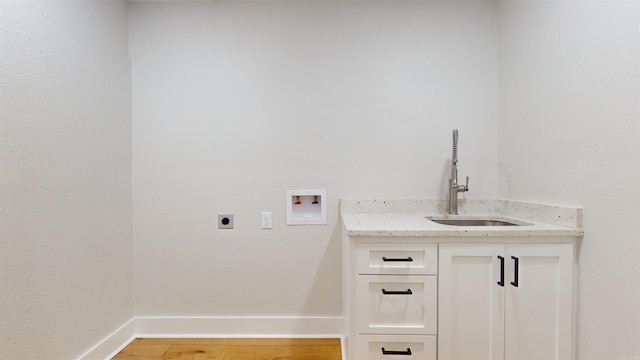 clothes washing area with washer hookup, cabinet space, a sink, electric dryer hookup, and baseboards