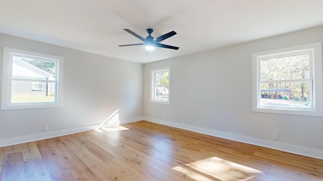 unfurnished room featuring light wood-type flooring, a ceiling fan, and baseboards