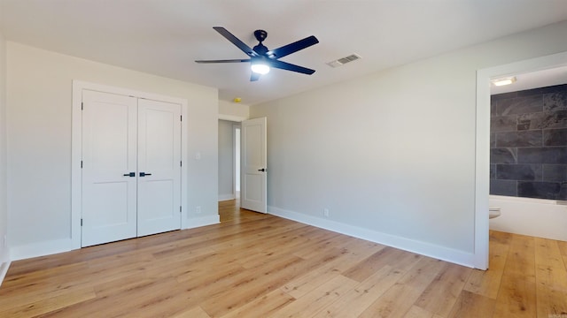 unfurnished bedroom featuring a closet, visible vents, connected bathroom, light wood-type flooring, and baseboards