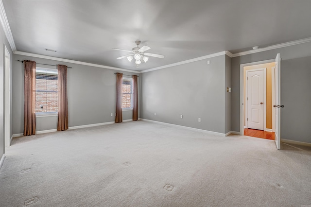 spare room featuring light carpet, baseboards, visible vents, and ornamental molding