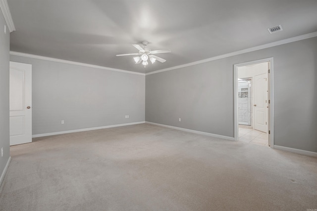 spare room featuring light carpet, baseboards, visible vents, a ceiling fan, and ornamental molding