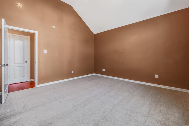 empty room featuring high vaulted ceiling, carpet flooring, and baseboards