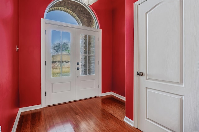 entryway featuring baseboards, wood finished floors, and french doors