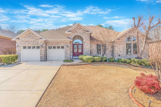 single story home with concrete driveway, brick siding, an attached garage, and roof with shingles