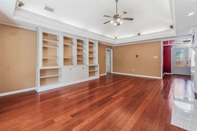 unfurnished living room with wood finished floors, ornamental molding, a raised ceiling, and visible vents