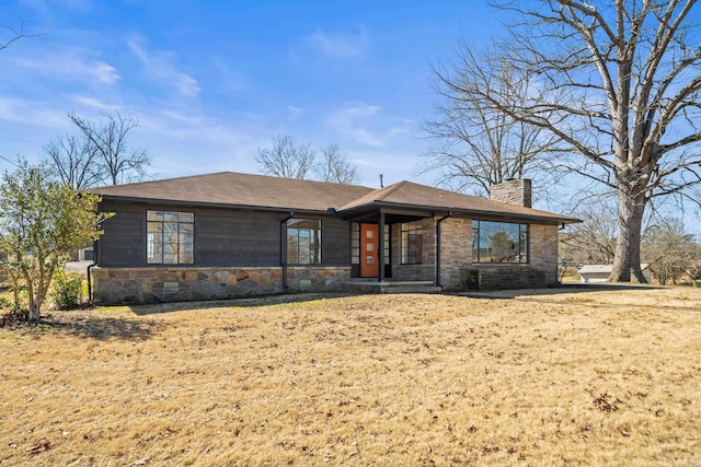 view of front of home with stone siding and a chimney