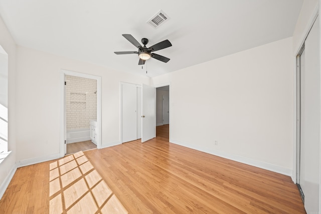 unfurnished bedroom with light wood finished floors, baseboards, visible vents, a ceiling fan, and ensuite bath