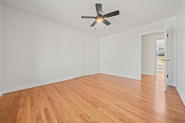 unfurnished room with light wood-type flooring, a ceiling fan, and baseboards