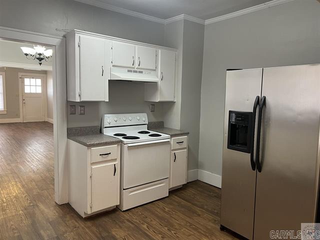 kitchen featuring electric stove, crown molding, dark wood-type flooring, under cabinet range hood, and stainless steel fridge with ice dispenser