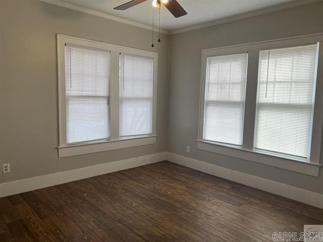 spare room featuring dark wood-style floors, baseboards, and ornamental molding