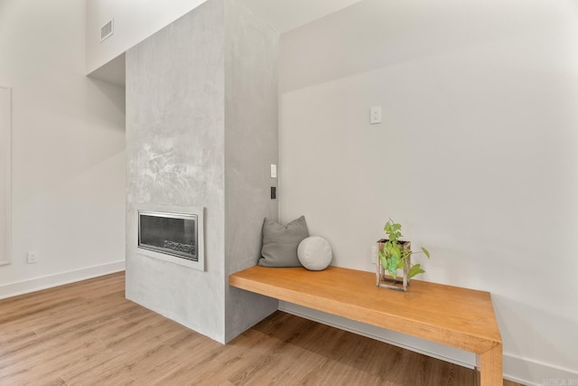 mudroom with a fireplace, baseboards, and wood finished floors