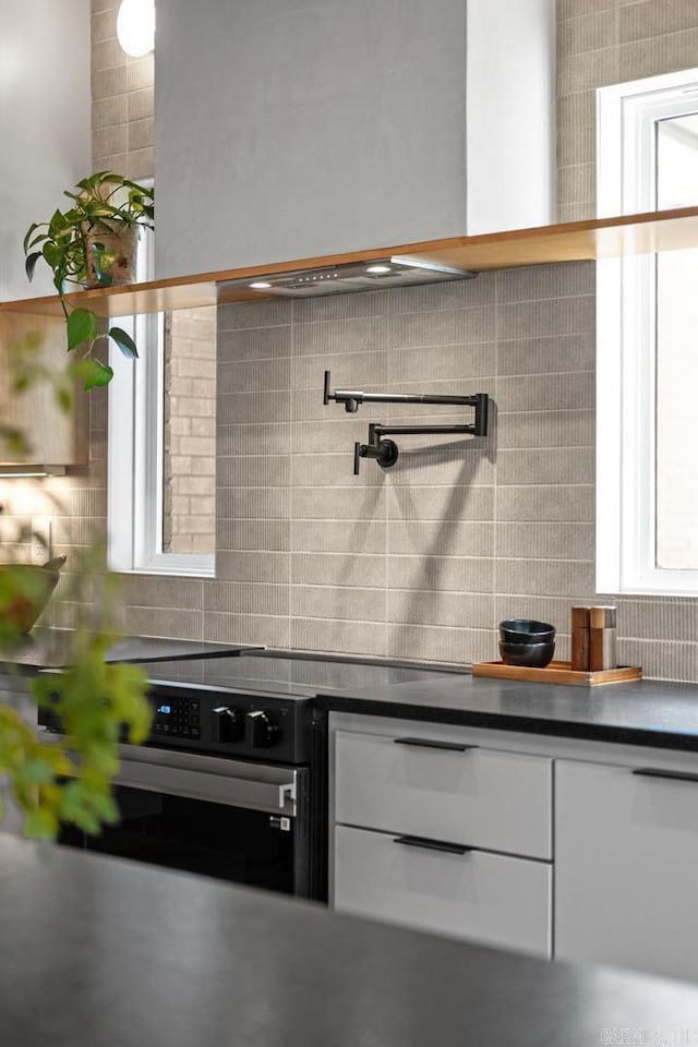 kitchen featuring tasteful backsplash, dark countertops, wall oven, and white cabinets