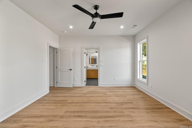 unfurnished bedroom featuring visible vents, baseboards, light wood-style flooring, ensuite bathroom, and recessed lighting