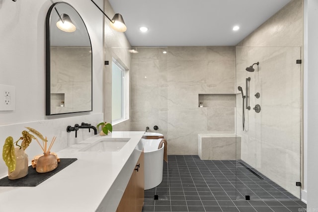 full bathroom with tile patterned flooring, vanity, tile walls, a freestanding bath, and a tile shower