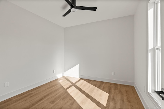 unfurnished room with light wood-style floors, plenty of natural light, and baseboards