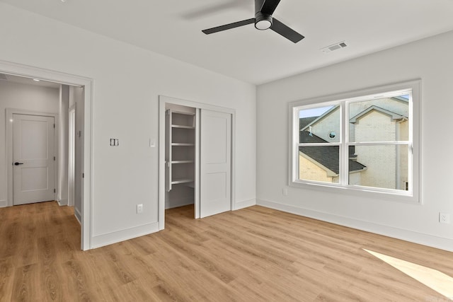 unfurnished bedroom featuring light wood finished floors, a closet, visible vents, a ceiling fan, and baseboards