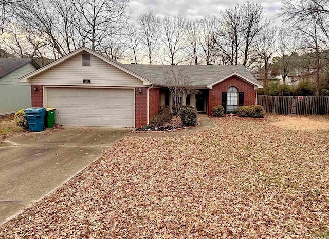 single story home featuring brick siding, fence, driveway, and an attached garage