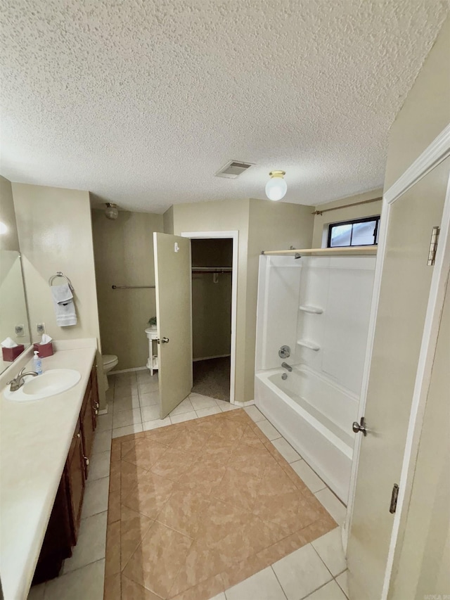 full bathroom featuring visible vents, toilet, a textured ceiling, vanity, and tile patterned floors