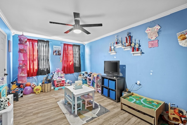 playroom featuring a ceiling fan, crown molding, and wood finished floors