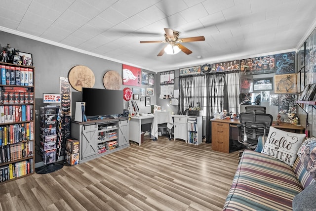 living room featuring wood finished floors, a ceiling fan, and crown molding