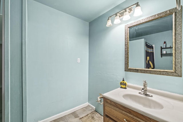 full bath featuring vanity and baseboards