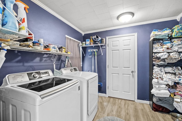 laundry area with laundry area, baseboards, washer and clothes dryer, ornamental molding, and light wood-type flooring