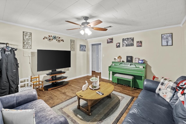 living area with ceiling fan, ornamental molding, wood finished floors, and baseboards