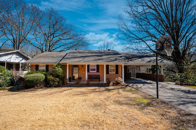 single story home featuring brick siding, covered porch, a carport, driveway, and a front lawn