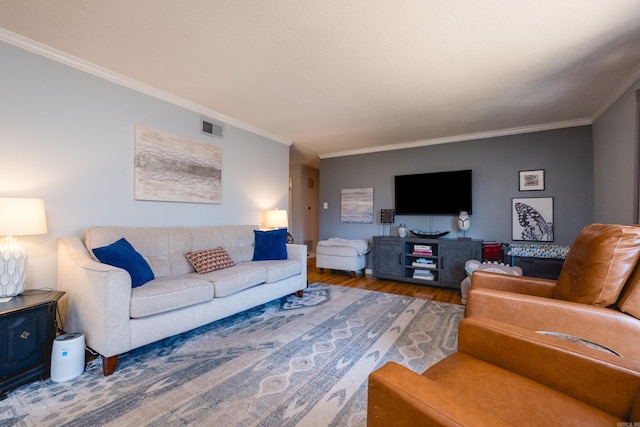 living room with wood finished floors, visible vents, and crown molding