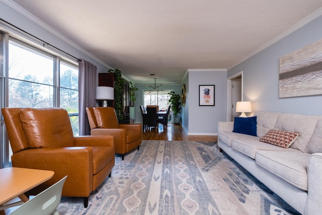 living room with baseboards, a textured ceiling, wood finished floors, and crown molding