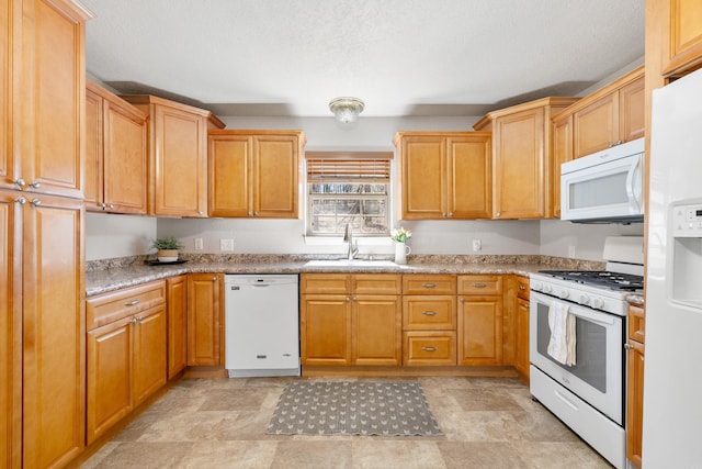 kitchen with white appliances, a textured ceiling, and a sink