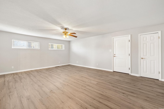 spare room with a ceiling fan, a textured ceiling, baseboards, and wood finished floors