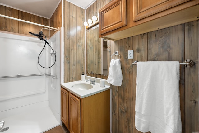 full bathroom featuring a stall shower, vanity, and wooden walls