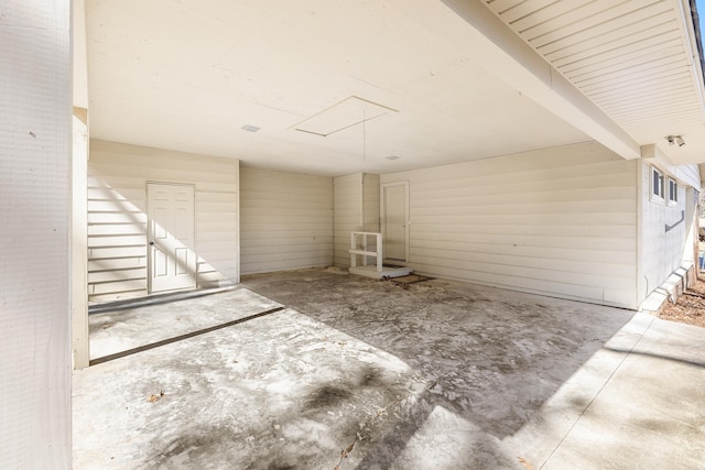 empty room featuring attic access and unfinished concrete floors