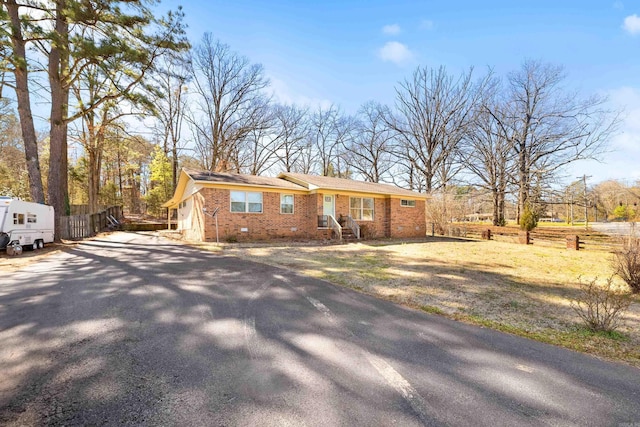 view of front of home with crawl space, brick siding, and driveway