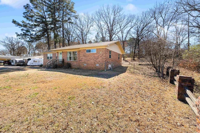 view of front of home featuring brick siding, crawl space, a front lawn, and fence