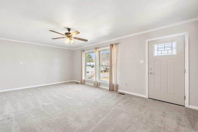 carpeted foyer with baseboards, ceiling fan, visible vents, and crown molding