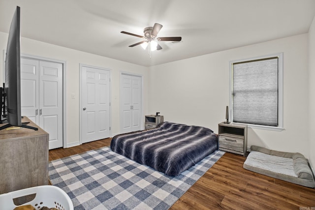 bedroom with multiple closets, ceiling fan, and wood finished floors